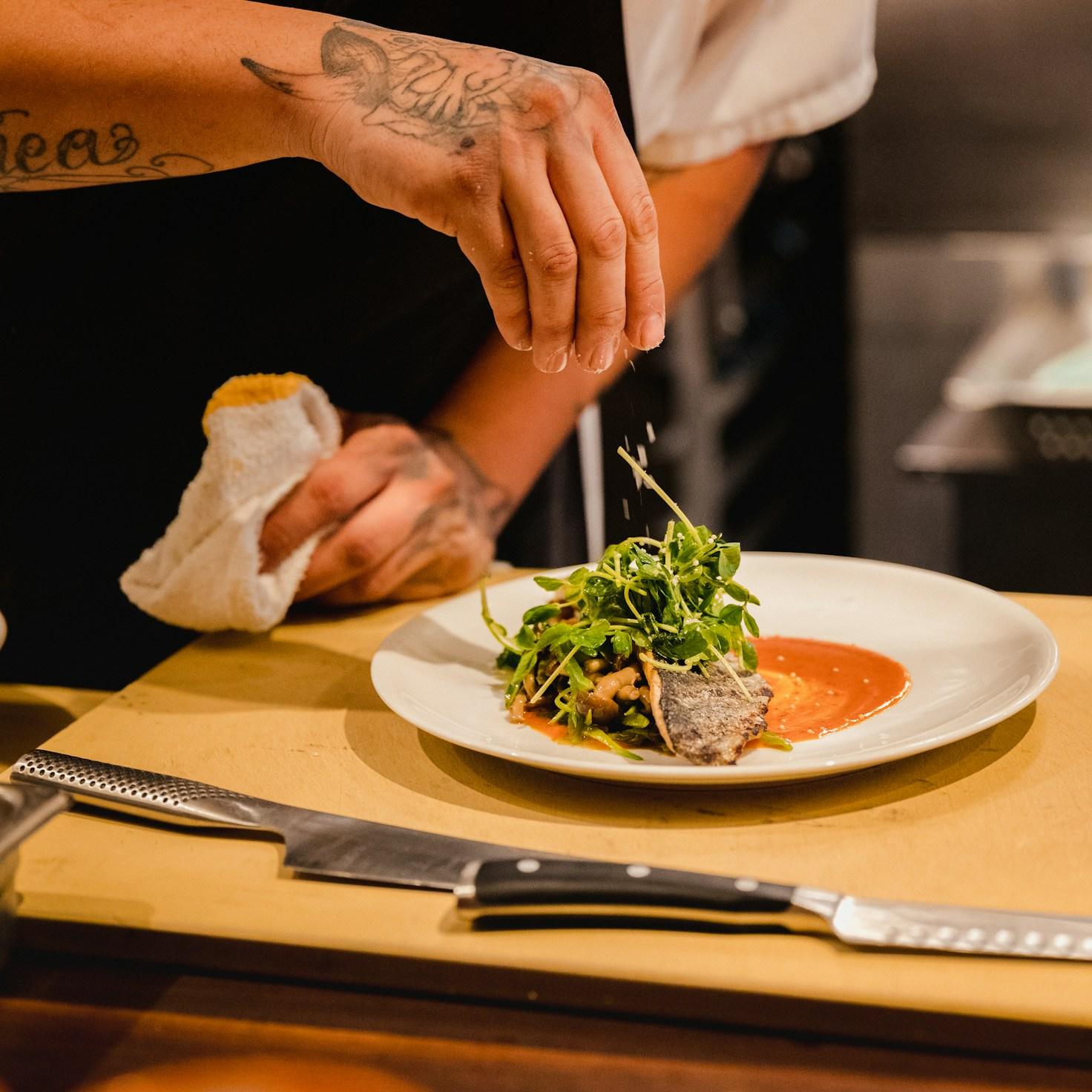 Diverse group of community members sharing a meal together, showcasing the social bonds formed through collaborative cooking